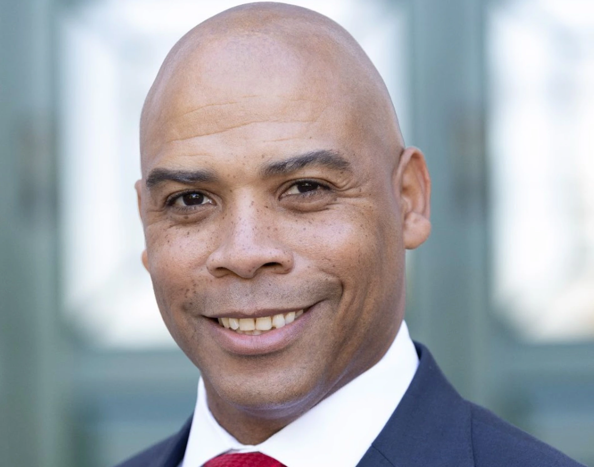 A man in suit and tie smiling for the camera.