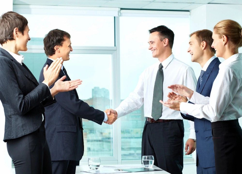 A group of people in suits shaking hands.