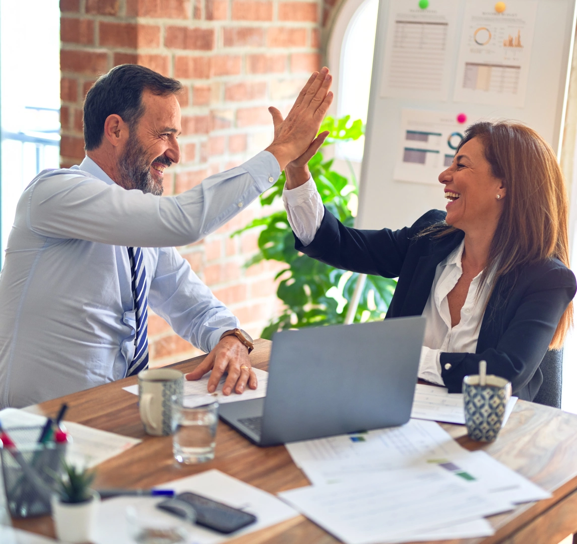 Two people giving each other a high five at the table